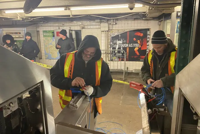 Transit workers installing OMNY readers at W. 4th Street, which are set to go live next week